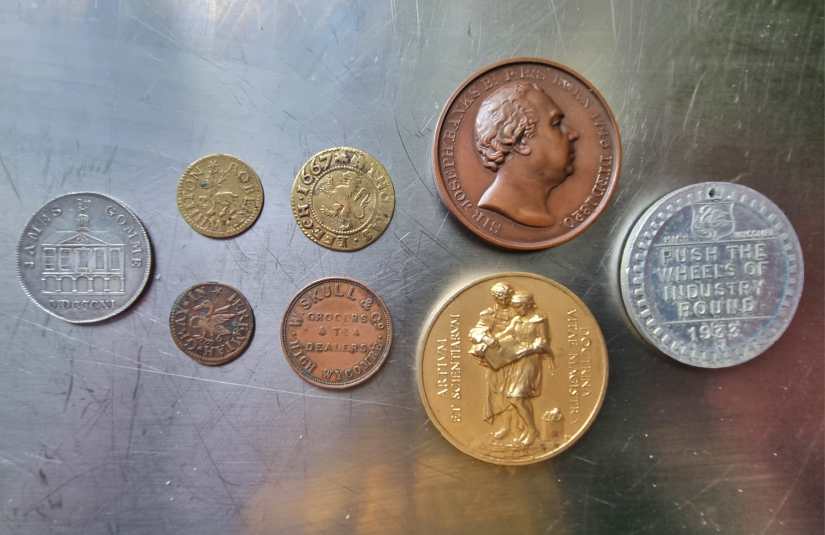 Photo shows 8 coins of different sizes, colours and designs lying on a shiny surface